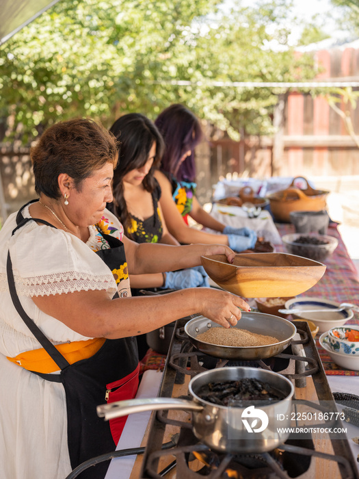 Right view image of an Indigenous family preparing Indigenous, Mexican foods