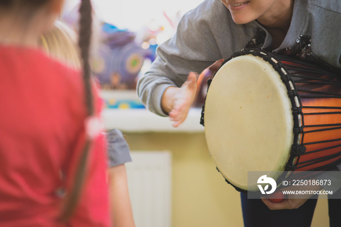 The girl plays the Djembe drum for children