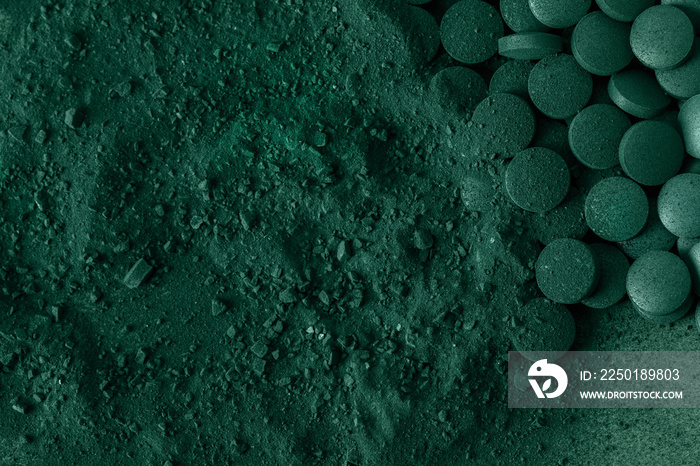 绿色螺旋藻片和粉末营养补充剂宏观特写俯视图。