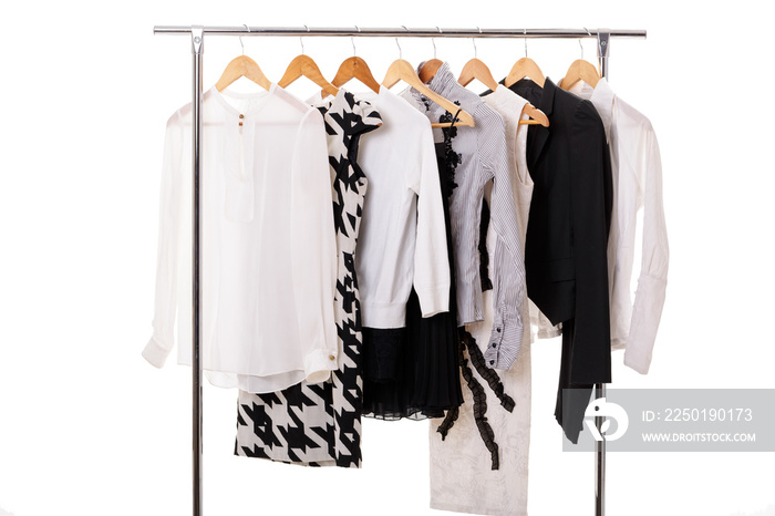 black and white womens clothes on hangers on rack on white backg