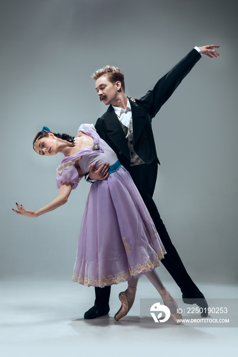 One unit. Beautiful contemporary ballroom dancers isolated on grey studio background. Sensual proffe