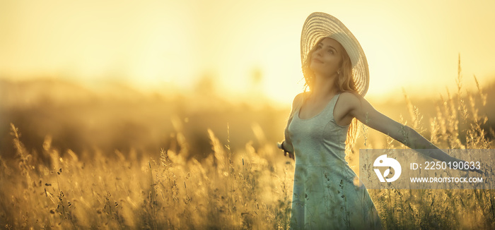 Happy young woman on the sunset or sunrise in summer nature with open hands