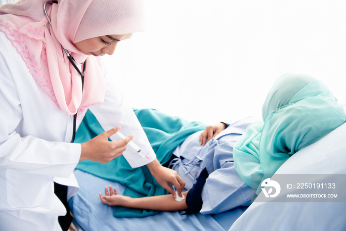 A beautiful young Muslim woman doctor wearing headphones, hand-held syringes, and a cotton ball is a