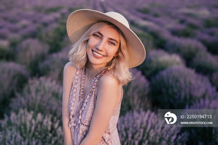 Charming young woman standing on lavender field