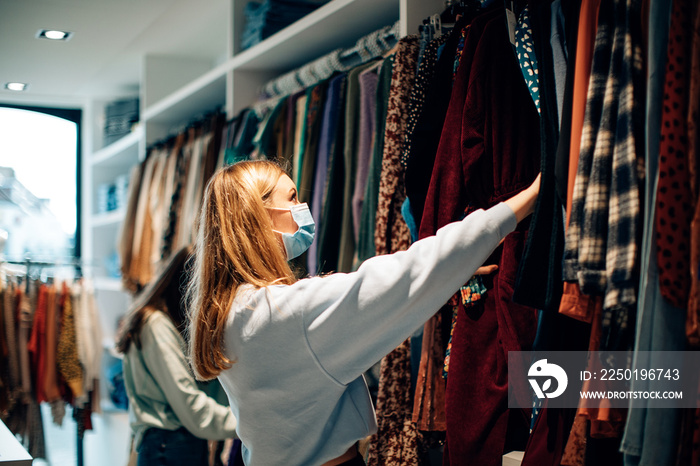 female customer wearing a protective face mask clothes shopping in a fashion boutique