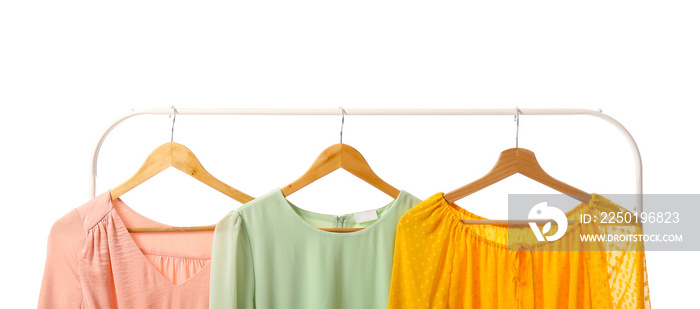 Rack with different stylish dresses on white background, closeup