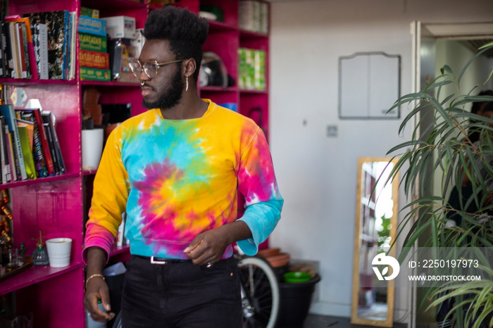 Young man wearing tie dye sweatshirt at home�