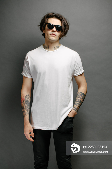 Hipster handsome male model with glasses wearing white blank t-shirt and black jeans with space for 