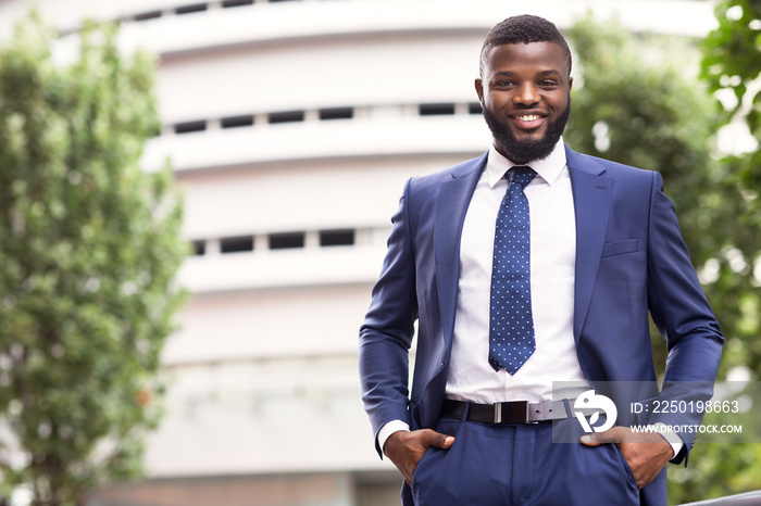 Handsome black man in suit against modern office center background