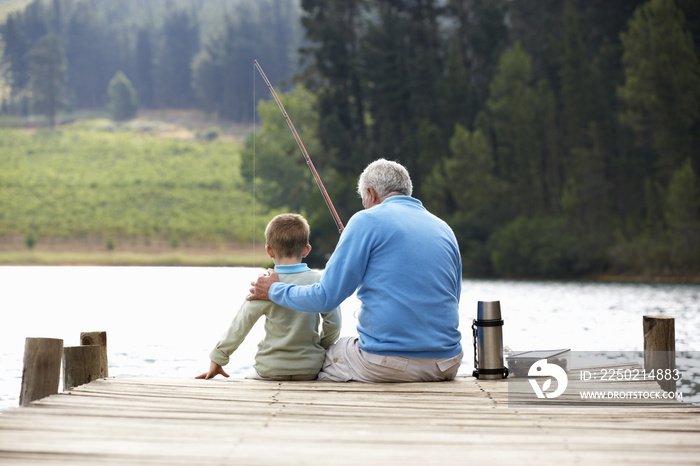 Senior man fishing with grandson