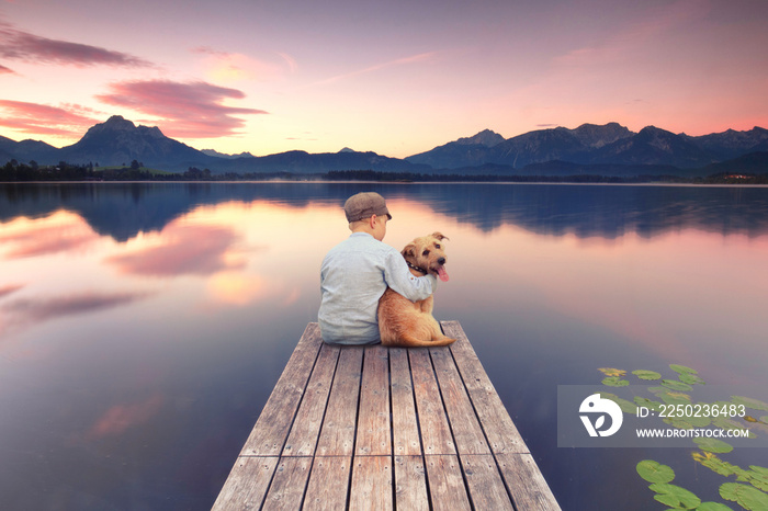 Junge mit seinem Hund am Steg