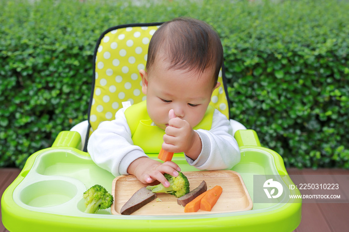 亚洲男婴通过婴儿断奶（BLW）进食。手指食物概念。