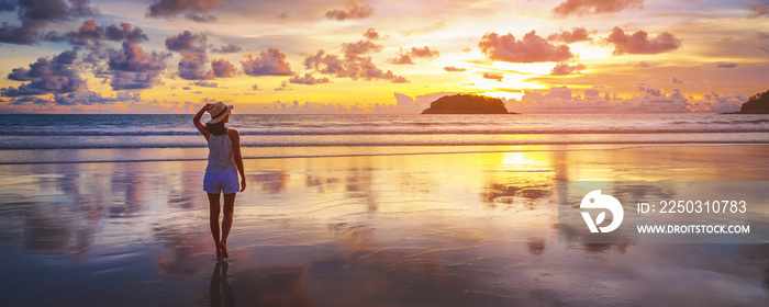 Traveler asian woman travel on Phuket beach in sunset Thailand