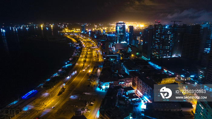 Road, lights and sea at night. Luanda city captured from the top