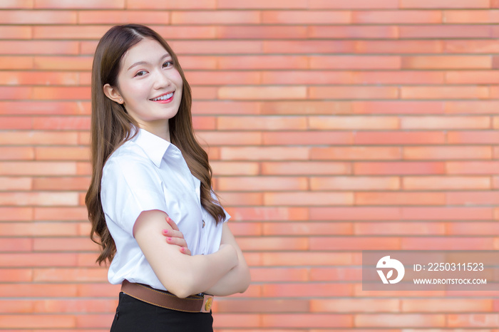 一名身穿大学生制服的泰国成年学生的肖像。与之站在一起的亚洲美女