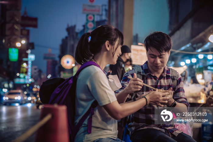 亚洲情侣在曼谷耀瓦拉特路唐人街夜市为游客就餐