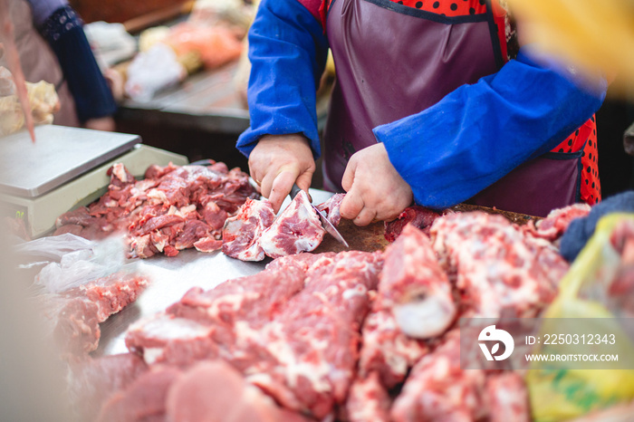 店员拿出一块肉，给买家切了一半。选择性聚焦照片