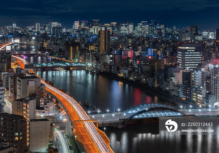 Aerial night panoramic view of the Sumida river bridges and higways light-up with the skyscrapers of