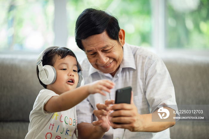 Happiness Asia grandfather  and grandson playing game in living room at home