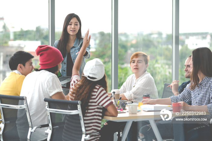 Young attractive asian creative hipster female leader standing at modern office happy talking and br