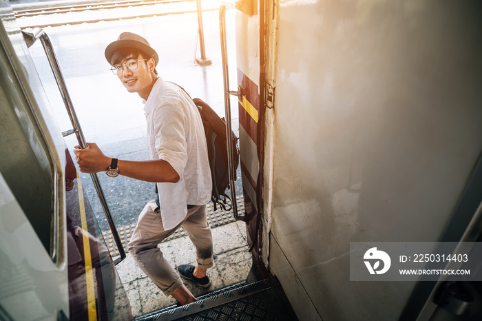 Asian man is traveler, he is waiting for their train. Outdoor adventure travel by train concept. Ban