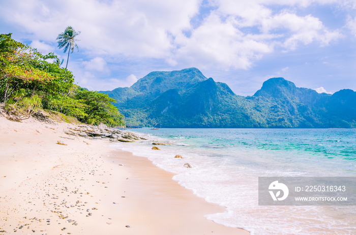 Stunning beach on Helicopter Island in the Bacuit archipelago in El Nido, Cadlao Island in Backgroun