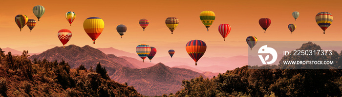 Hot air balloon above high mountain at sunset