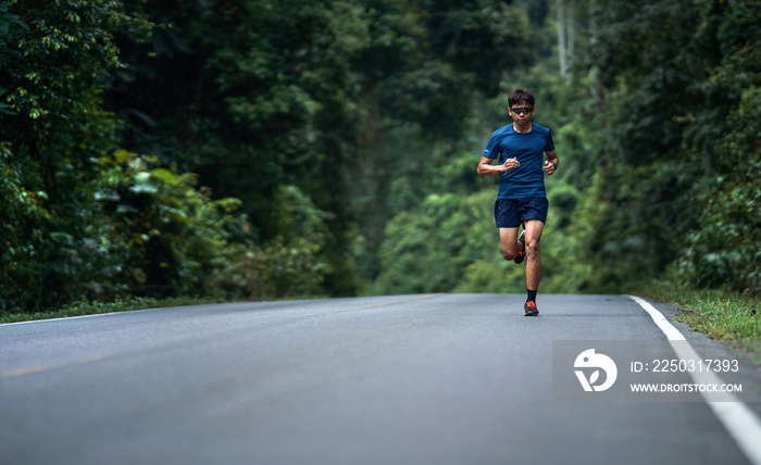 Asian man are running training in roads with forests.