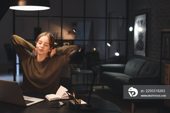 Tired beautiful woman working at home late in evening