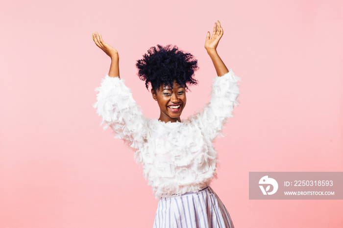 A very happy young woman with both arms up