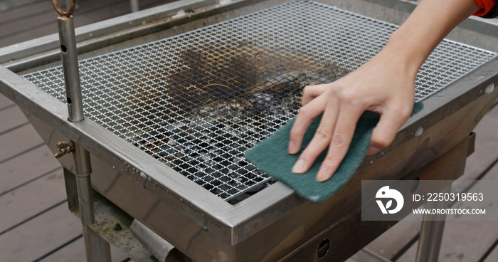 Woman clean the BBQ oven at outdoor