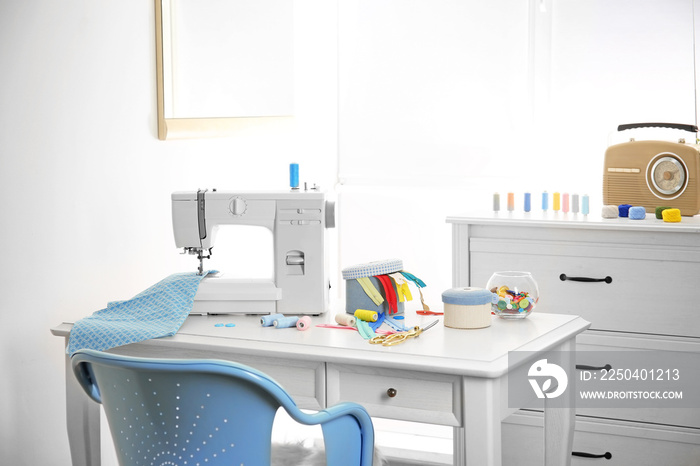 Sewing machine with fabric on table in tailor workshop