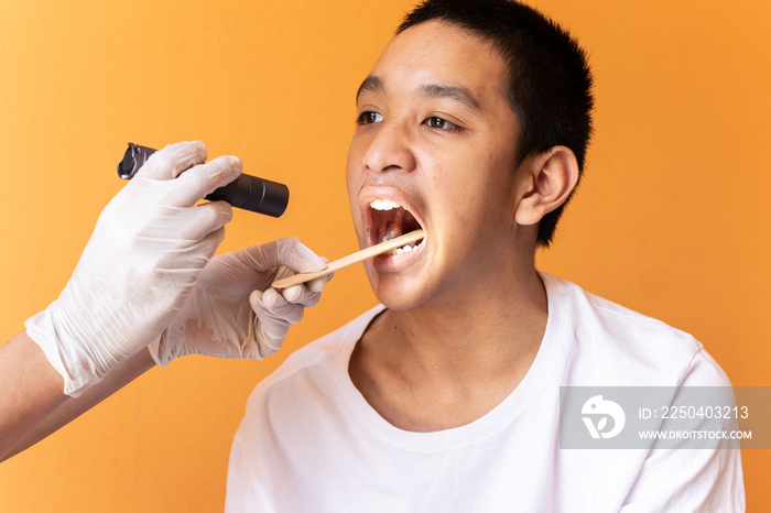 近距离医生检查使用压舌器的患者的喉咙。