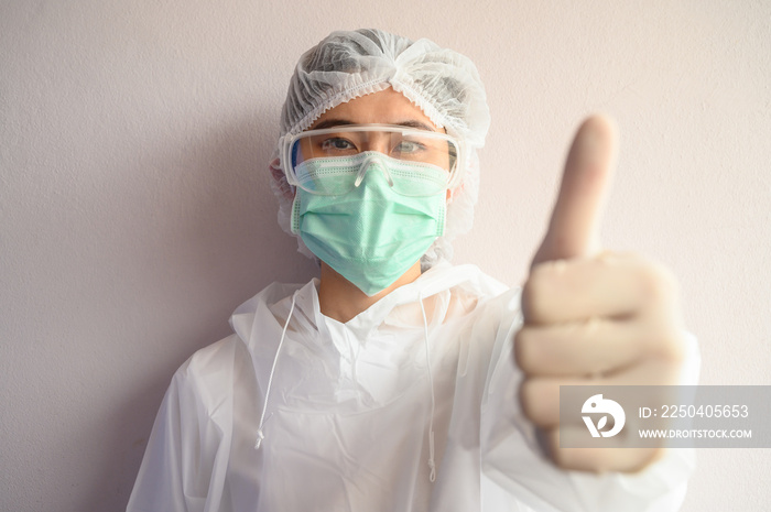 护士穿着PPE套装，戴着口罩保护病毒，竖起大拇指。在冠状病毒大流行中，你