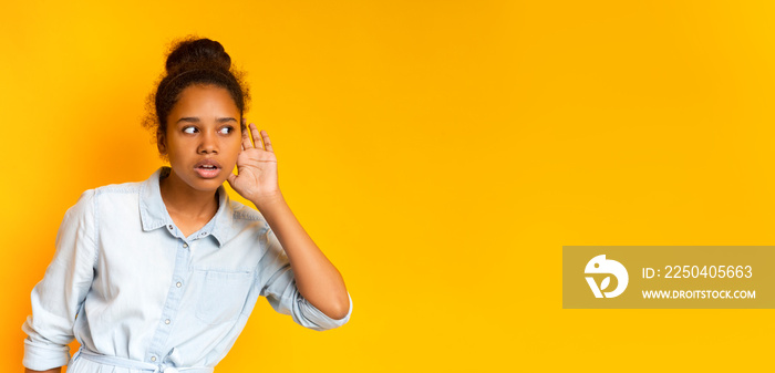 Curious teen girl holding hand at her ear