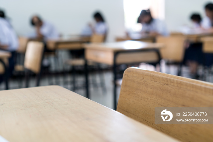 Blurred Woman Young Asian students group writing test paper answer sitting on taking final examinati