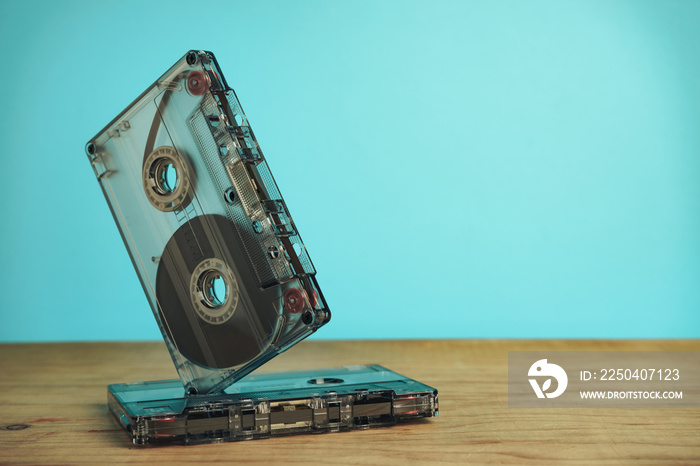 Beautiful Audio cassette tape on a red wooden table and blue space. Minimalism retro style concept. 