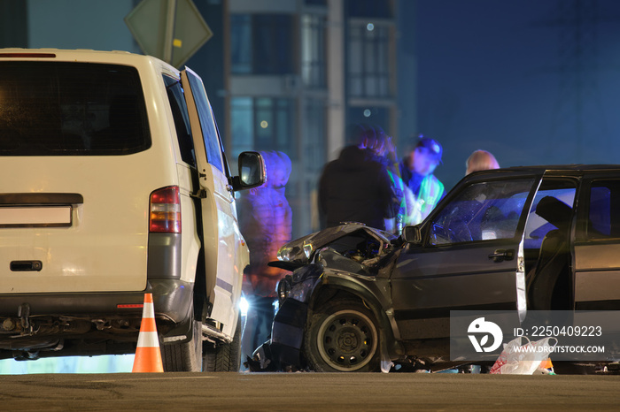 Cars crashed heavily in road accident after collision and silhouette of people on city street at nig