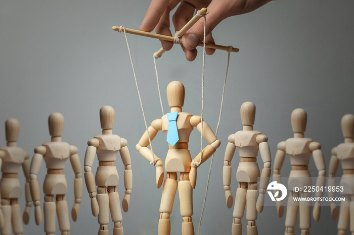Leader puppet activist and workers. Concept of how to manage leader in team. Doll in tie on the rope