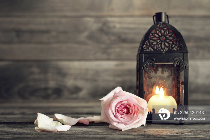 Memorial candle and rose on wooden background