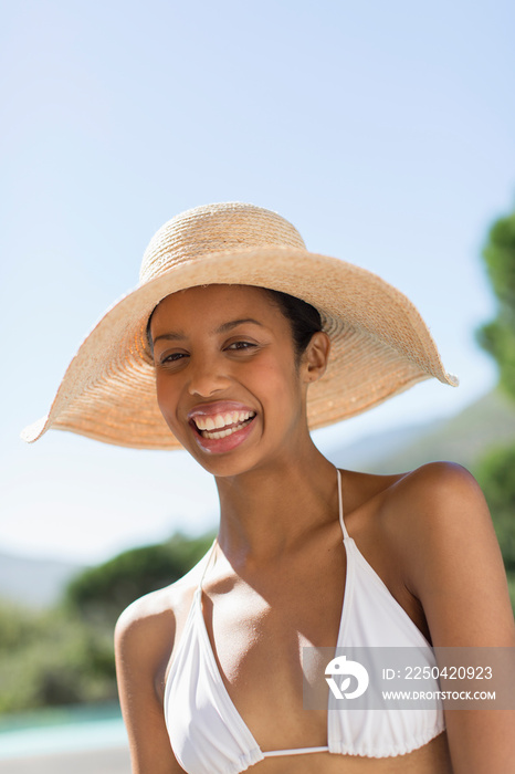 Portrait happy young woman in bikini and sun hat