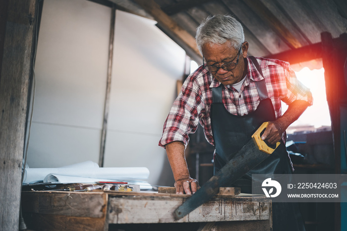 Senior old carpenter working on wood craft at workshop to produce construction material or wooden fu