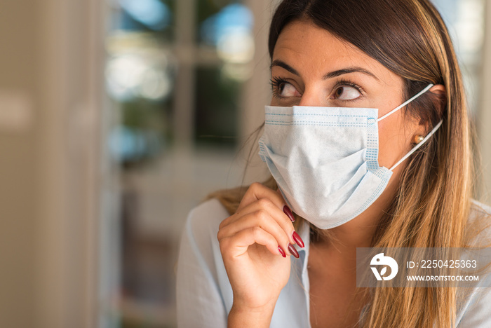 美丽的年轻女子在家戴着污染口罩。污染和疾病概念。