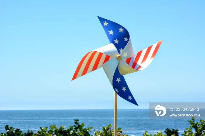 A Red White and Blue patriotic Pinwheel with blue sky and ocean