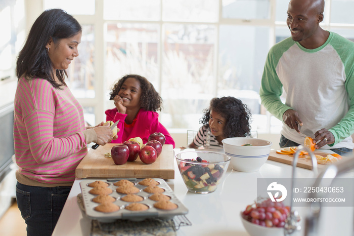 Family of four preparing healthy snacks