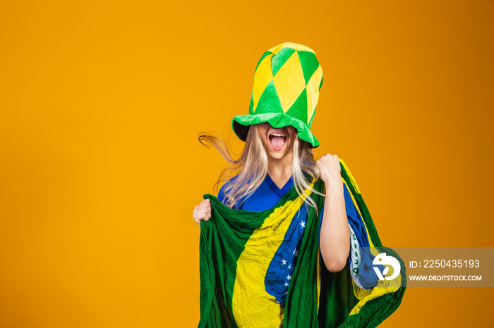 金发巴西球迷在黄色背景下庆祝。是的！