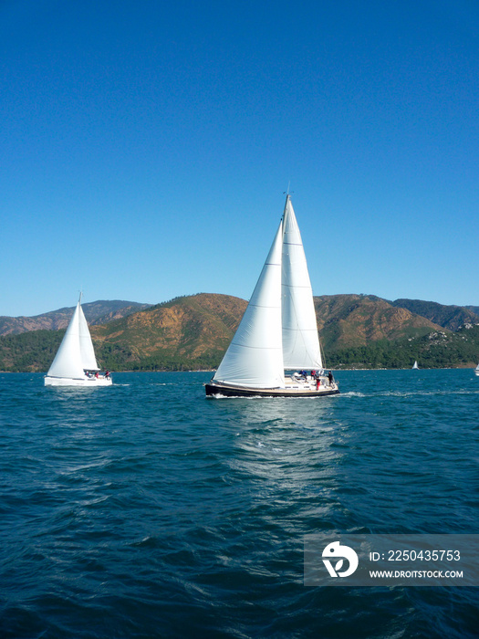 帆船游艇帆船赛碧海蓝天和高山背景