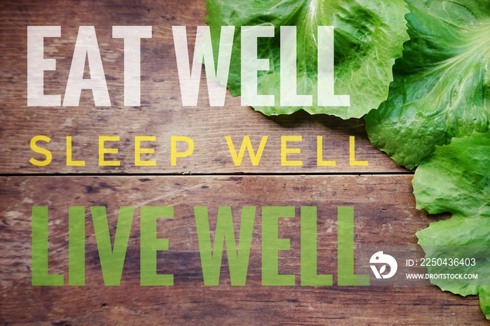 Eat well sleep well live well words on old wooden background with fresh green lettuce