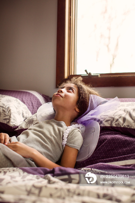 Girl (4-5) lying down in bed