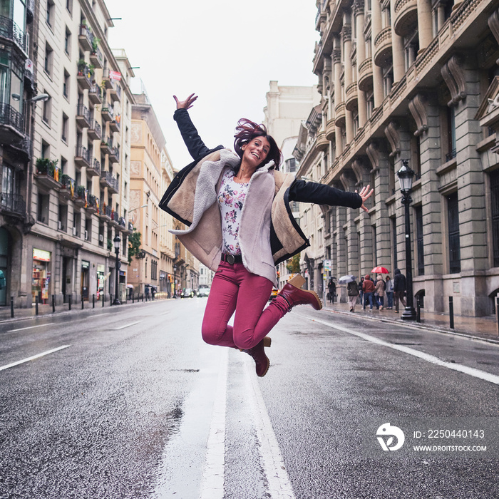 chica joven saltando en la calle Via Laietana de Barcelona